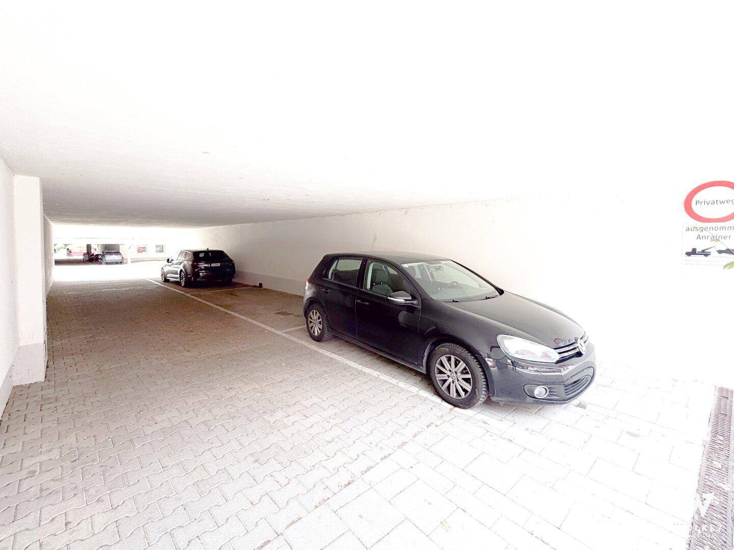 Helle Tiefgarage mit gepflastertem Boden und ausreichend Platz für mehrere Fahrzeuge.