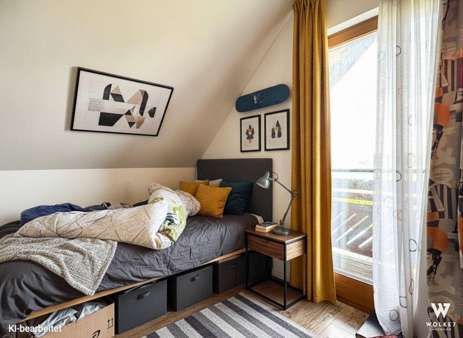 Jugendzimmer im Dachgeschoss mit Bett, Schreibtisch und Zugang zum Balkon.