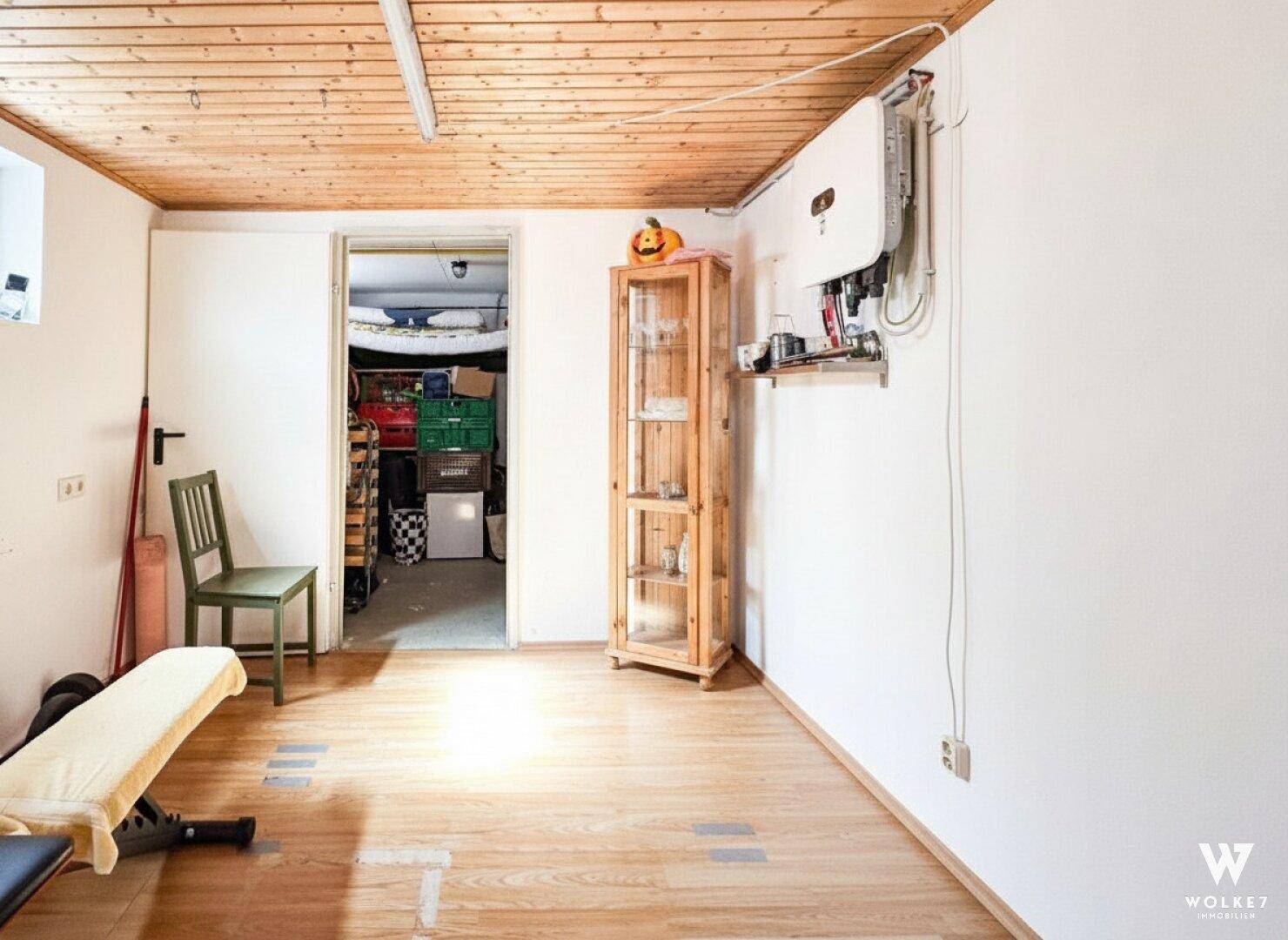 Geräumiger Kellerraum mit Fitnessbereich und Zugang zu weiterem Stauraum.
