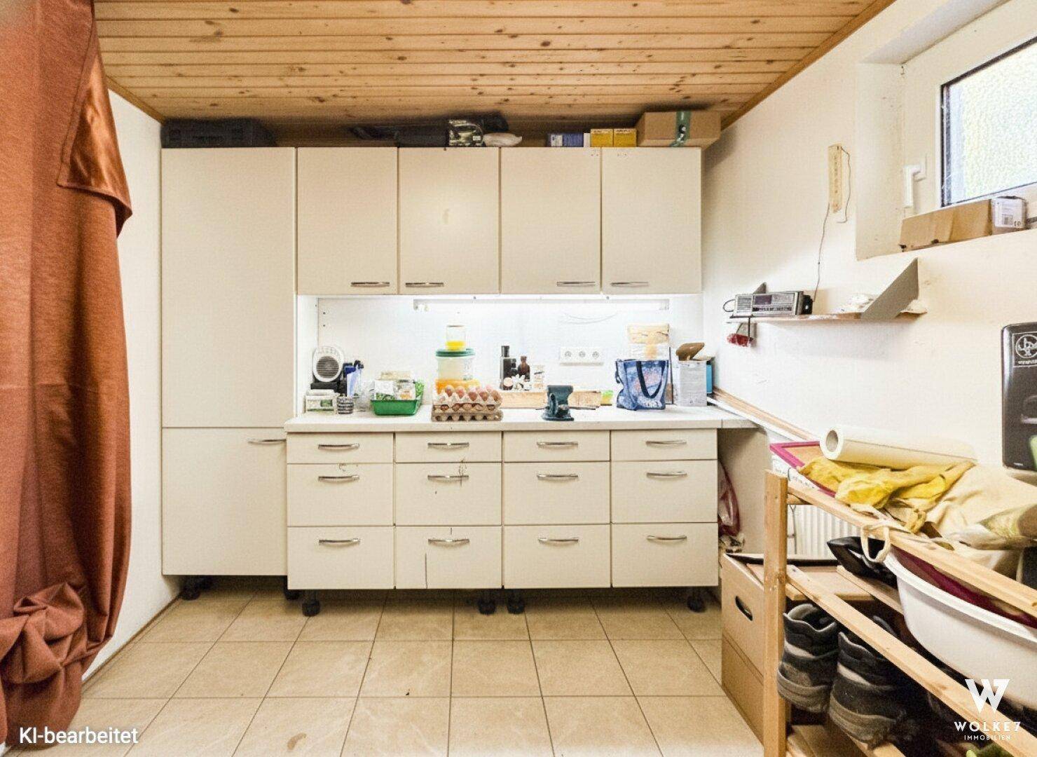 Praktische Abstellküche im Keller mit vielen Schränken und Arbeitsfläche.