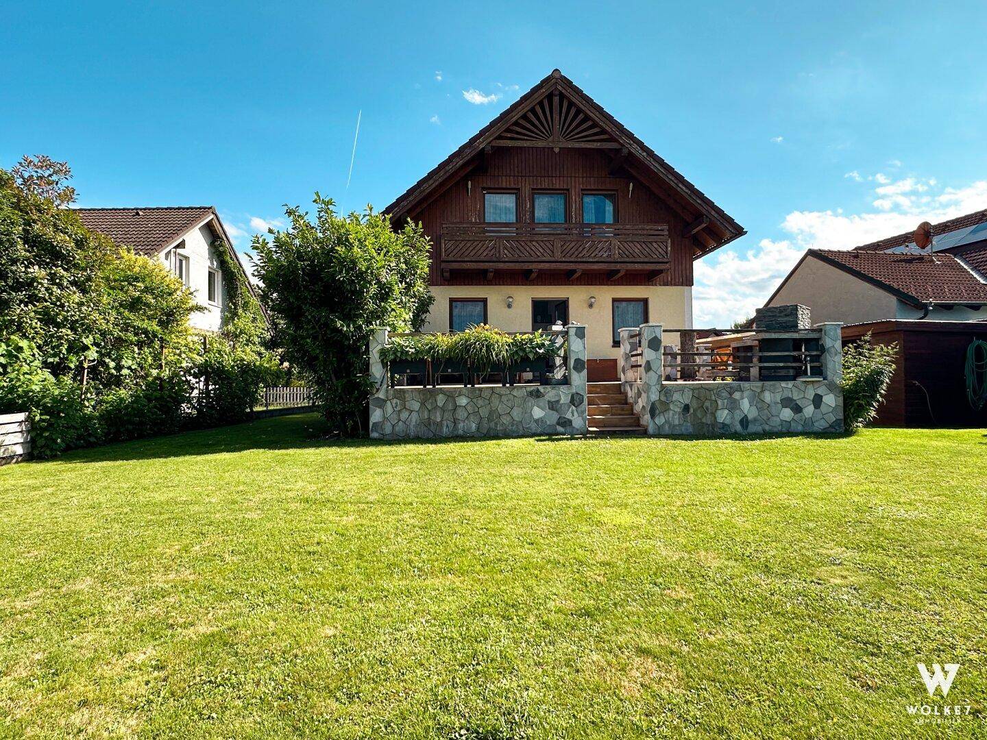 Großzügiger Gartenbereich mit Rasenfläche und Blick auf das charmante Einfamilienhaus.