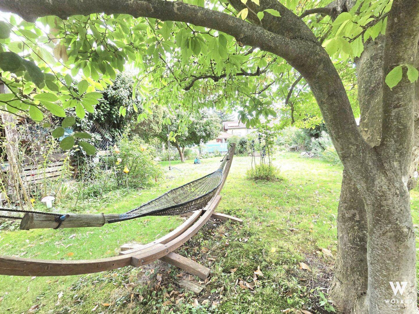 Ruhiger Gartenbereich mit einer Hängematte zwischen Bäumen, ideal zum Entspannen und Verweilen.