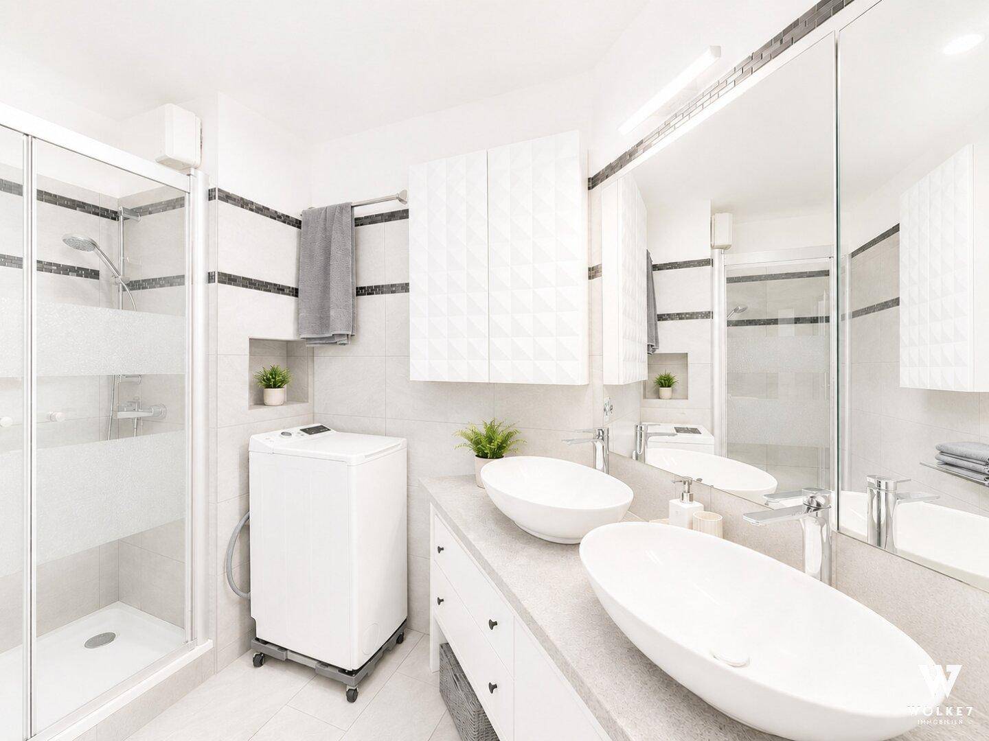 Modernes Badezimmer mit Doppelwaschbecken, Duschkabine und integrierter Waschmaschine.