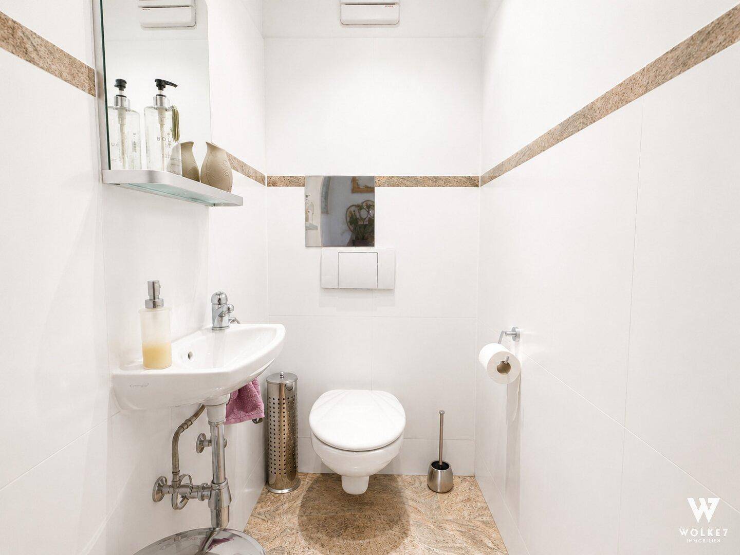 Kleines Gäste-WC mit Wand-WC und modernem Waschbecken.