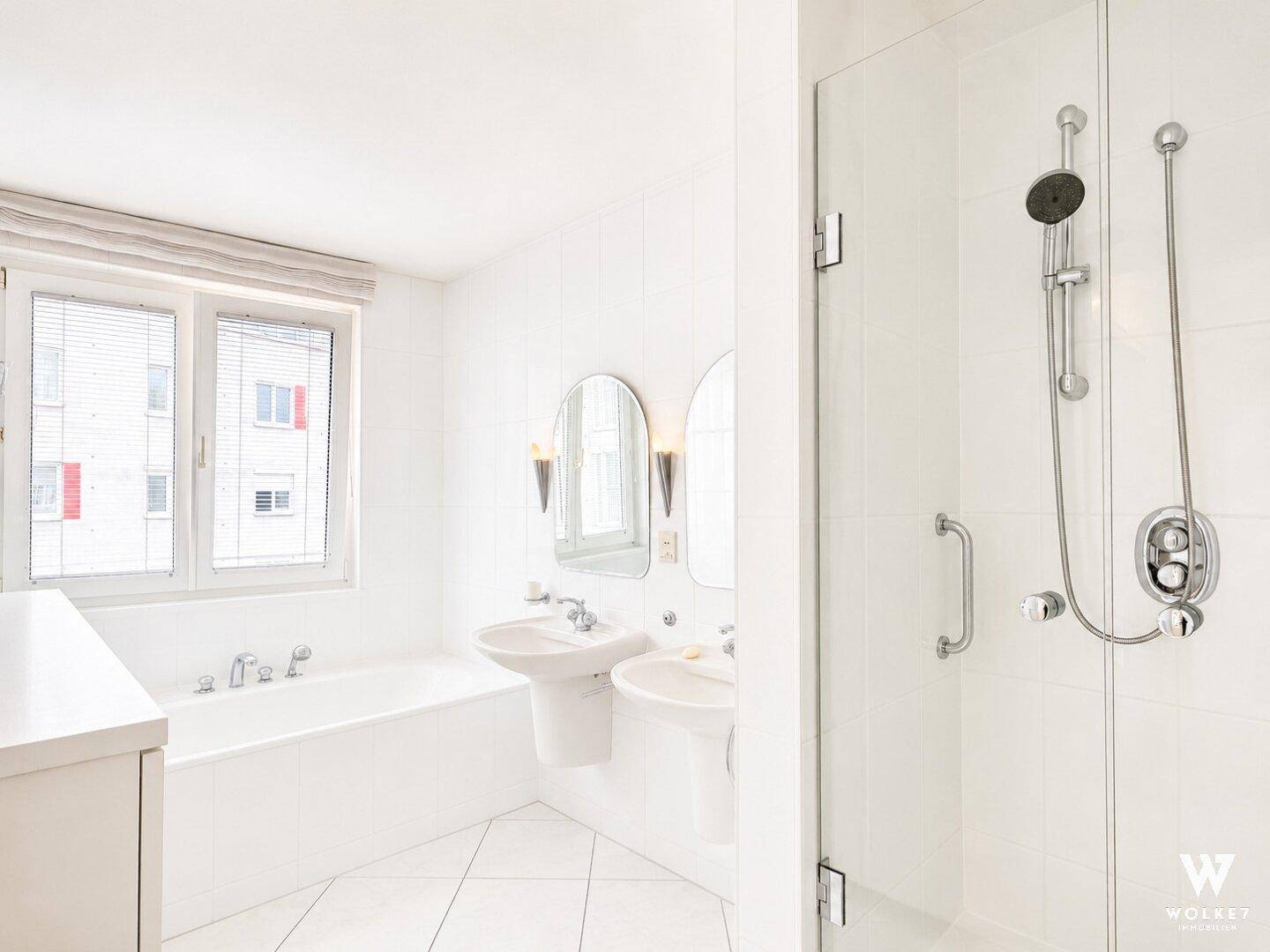 Modernes Badezimmer mit Badewanne, separater Dusche und zwei Waschbecken.