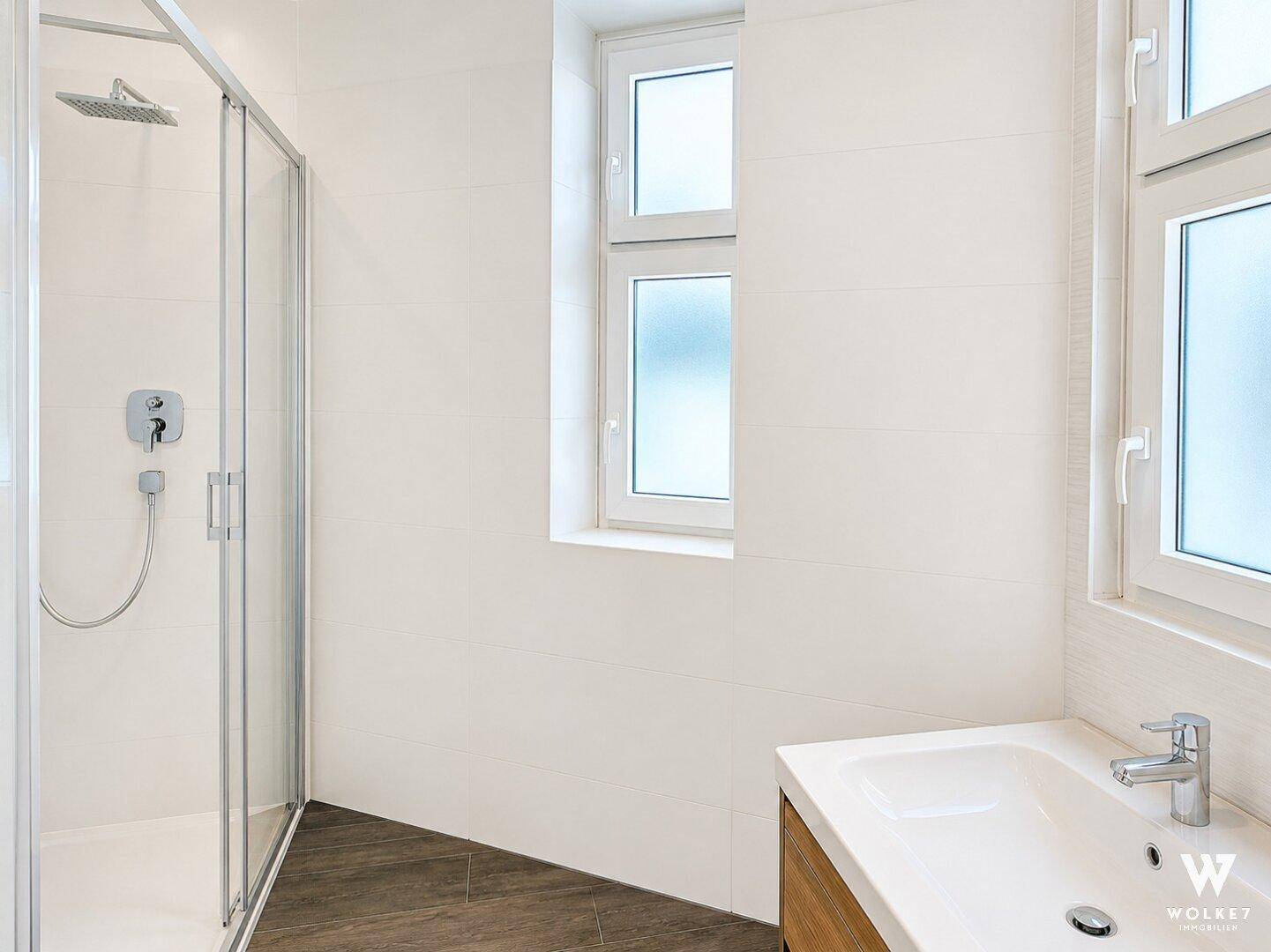 Helles Badezimmer mit moderner begehbarer Dusche und einem einzelnen Waschbecken.