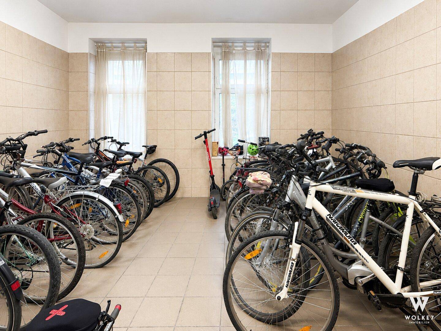 Fahrradraum mit zahlreichen Fahrrädern und einem Roller, ideal für Bewohner.