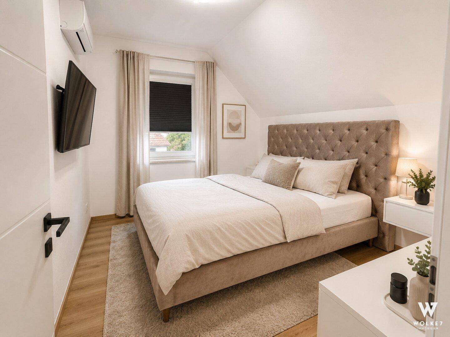 Gemütliches Schlafzimmer mit großem Bett, gepolstertem Kopfteil und Klimaanlage.