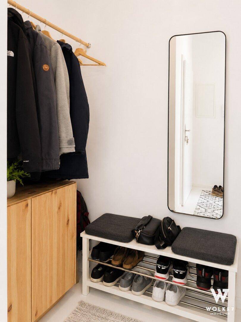 Funktionaler Flur mit Garderobe, Schuhregal und großem Spiegel für den Eingangsbereich.