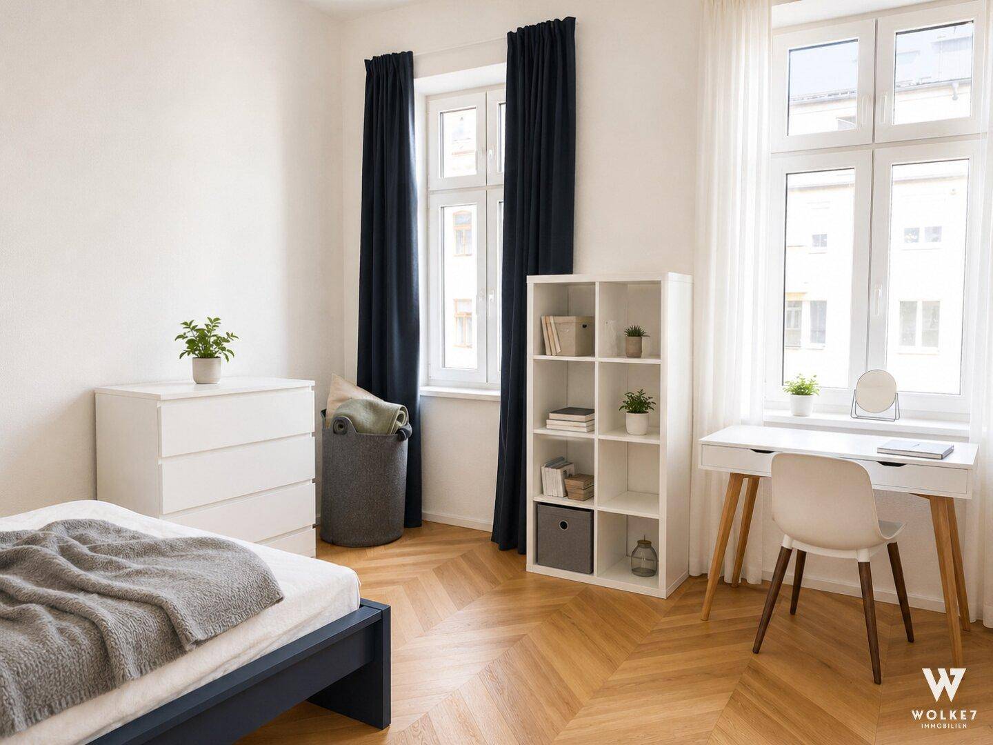 Helles Schlafzimmer mit Holzboden, Schreibtisch am Fenster und modernen Möbeln in ruhiger Atmosphäre.