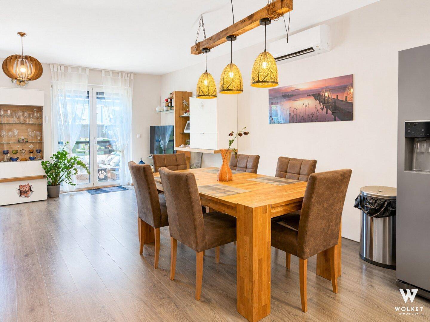 Heller Essbereich mit Holztisch, Klimaanlage und Zugang zur Terrasse oder zum Garten.