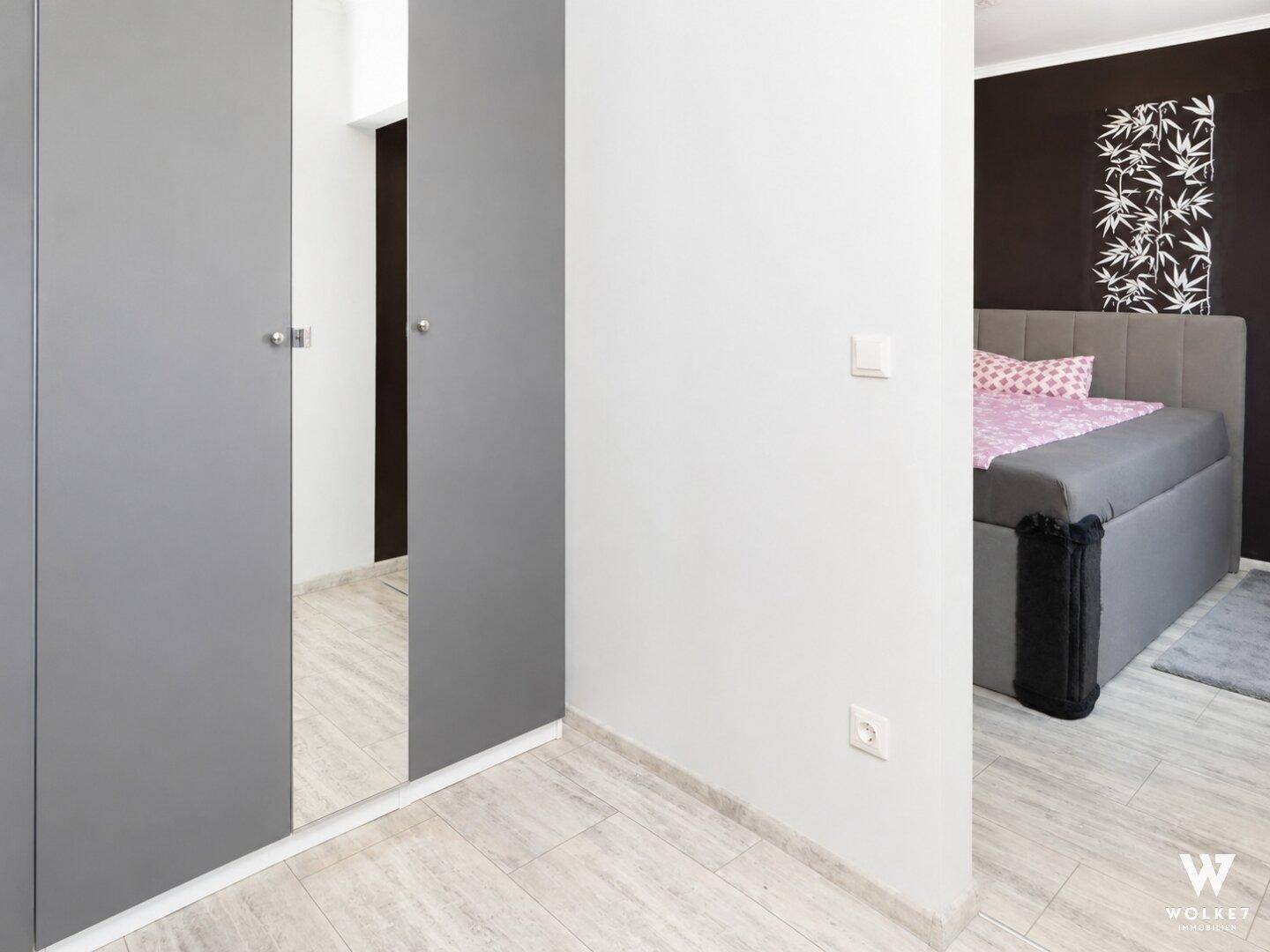 Schlafzimmer mit Zugang zu einem begehbaren Kleiderschrank, hell und funktional.
