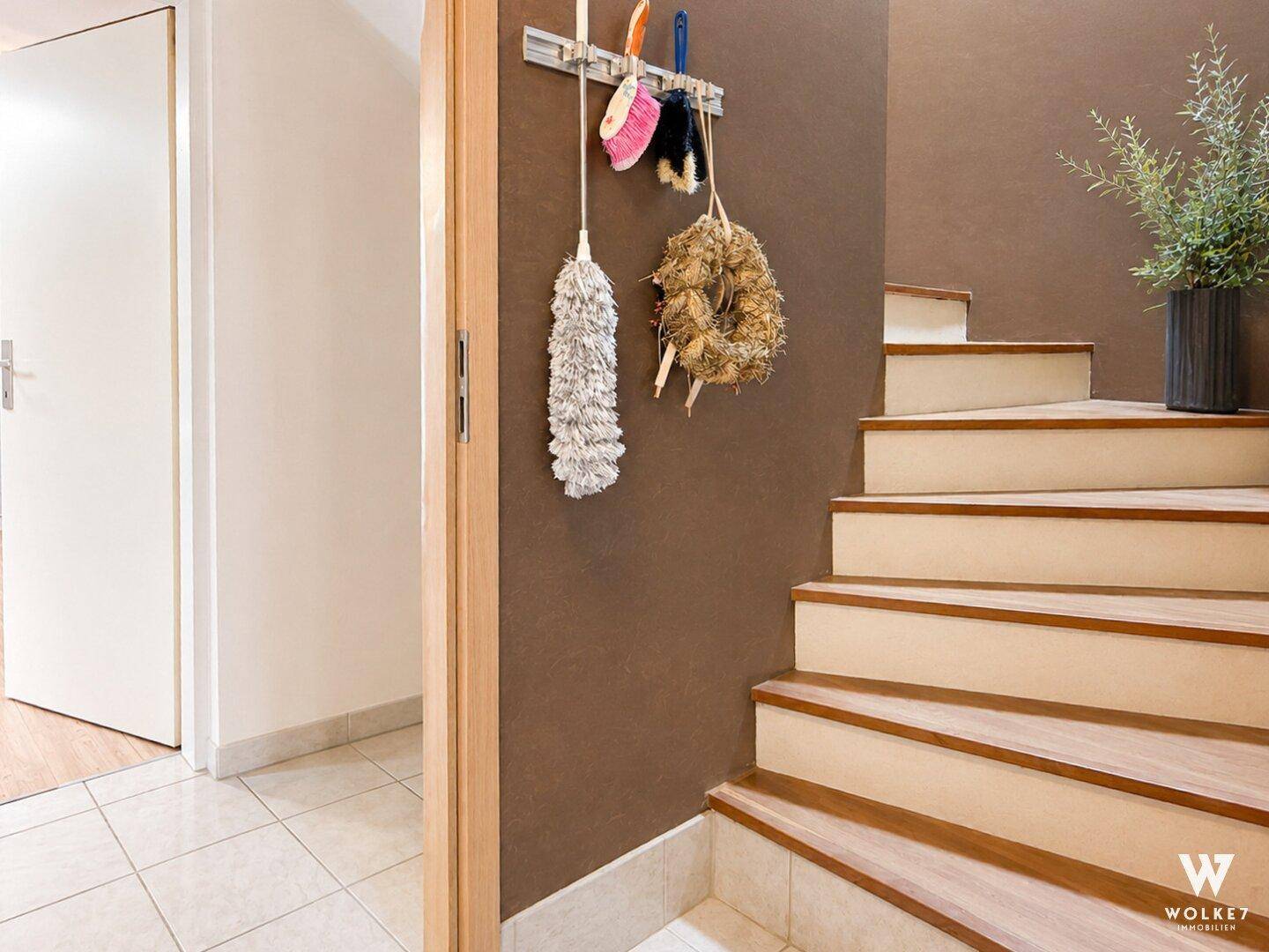 Eingangsbereich mit Holztreppe und dekorativer Wandgestaltung.