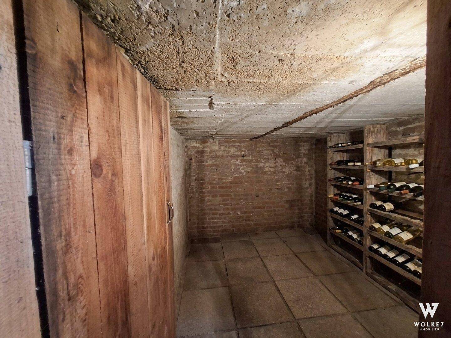 Rustikaler Weinkeller mit Ziegelwänden, Holzregalen und Fliesenboden.
