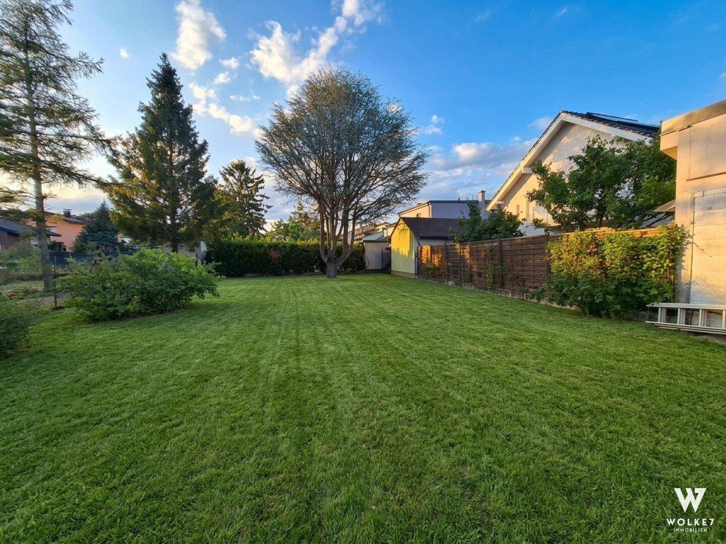 Großer, weitläufiger Garten mit gepflegtem Rasen, umgeben von Bäumen und Hecken.