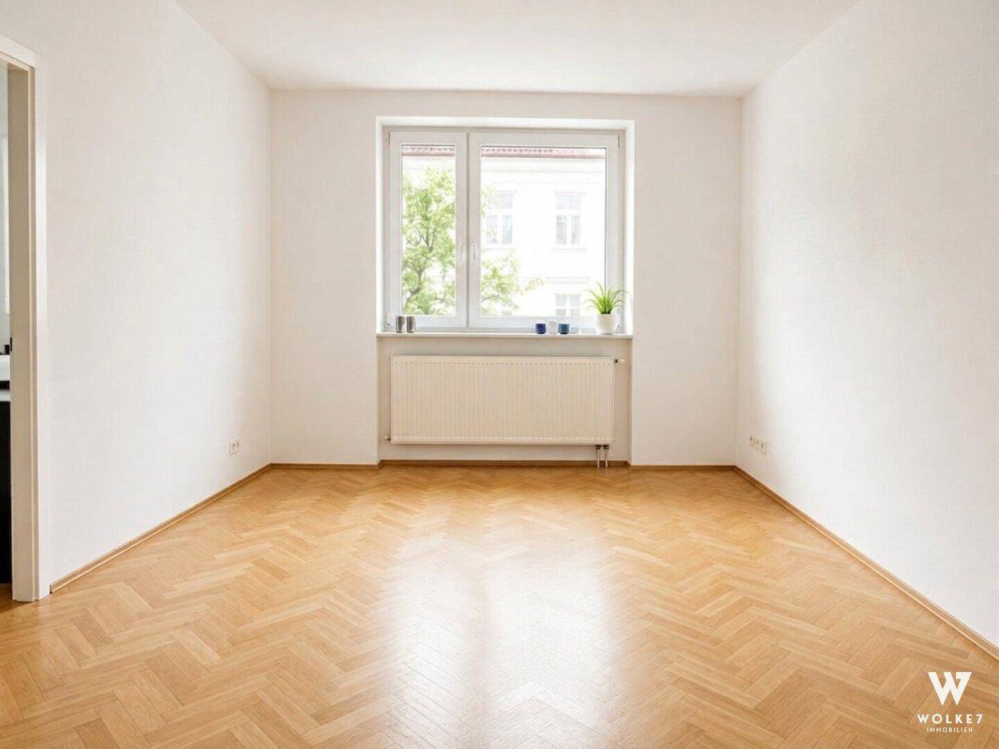 Leerer Raum mit Fischgrätparkett und großem Fenster, ideal für individuelle Gestaltung.