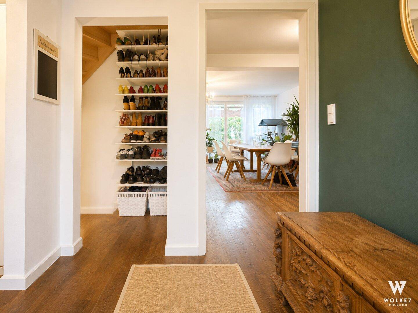 Eingangsbereich mit praktischem Schuhregal unter der Treppe und Blick in den Wohnbereich.