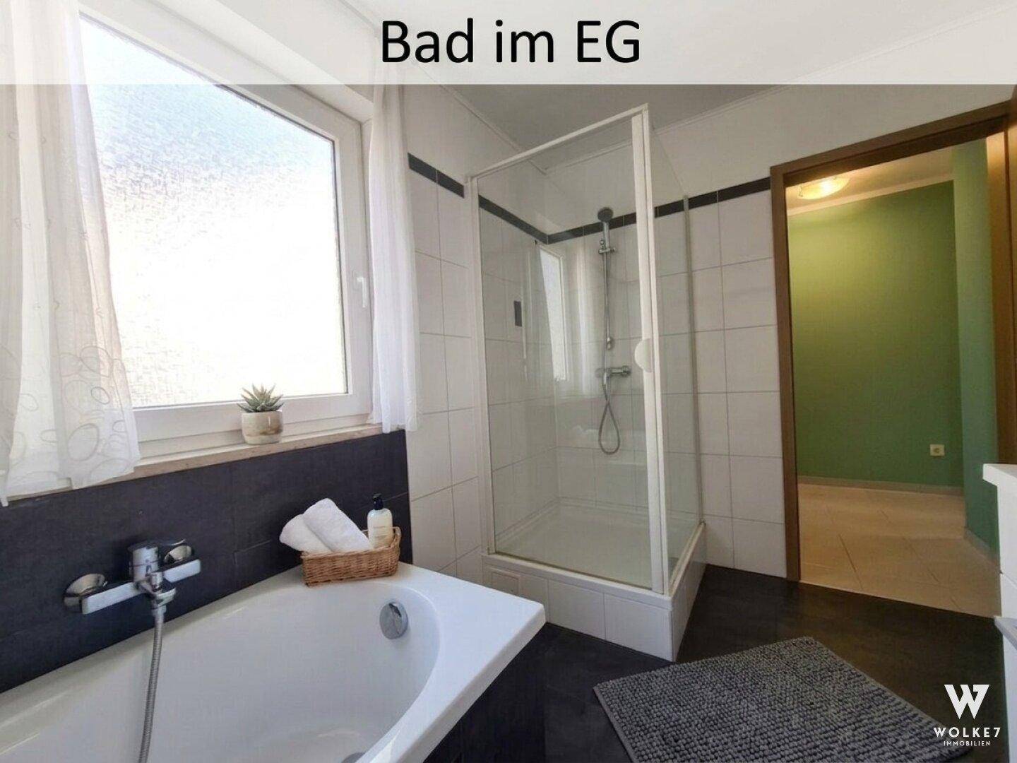 Badezimmer im Erdgeschoss mit Badewanne, Duschkabine und Fenster.