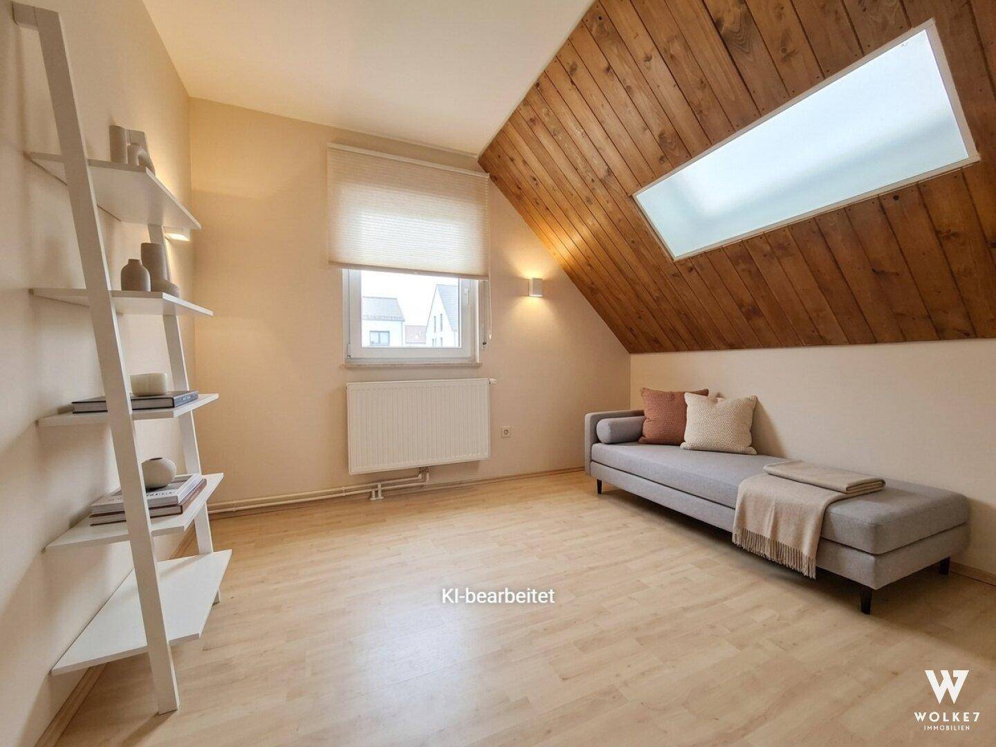 Gemütliches Dachzimmer mit Holzwand, Dachfenster und heller Einrichtung.