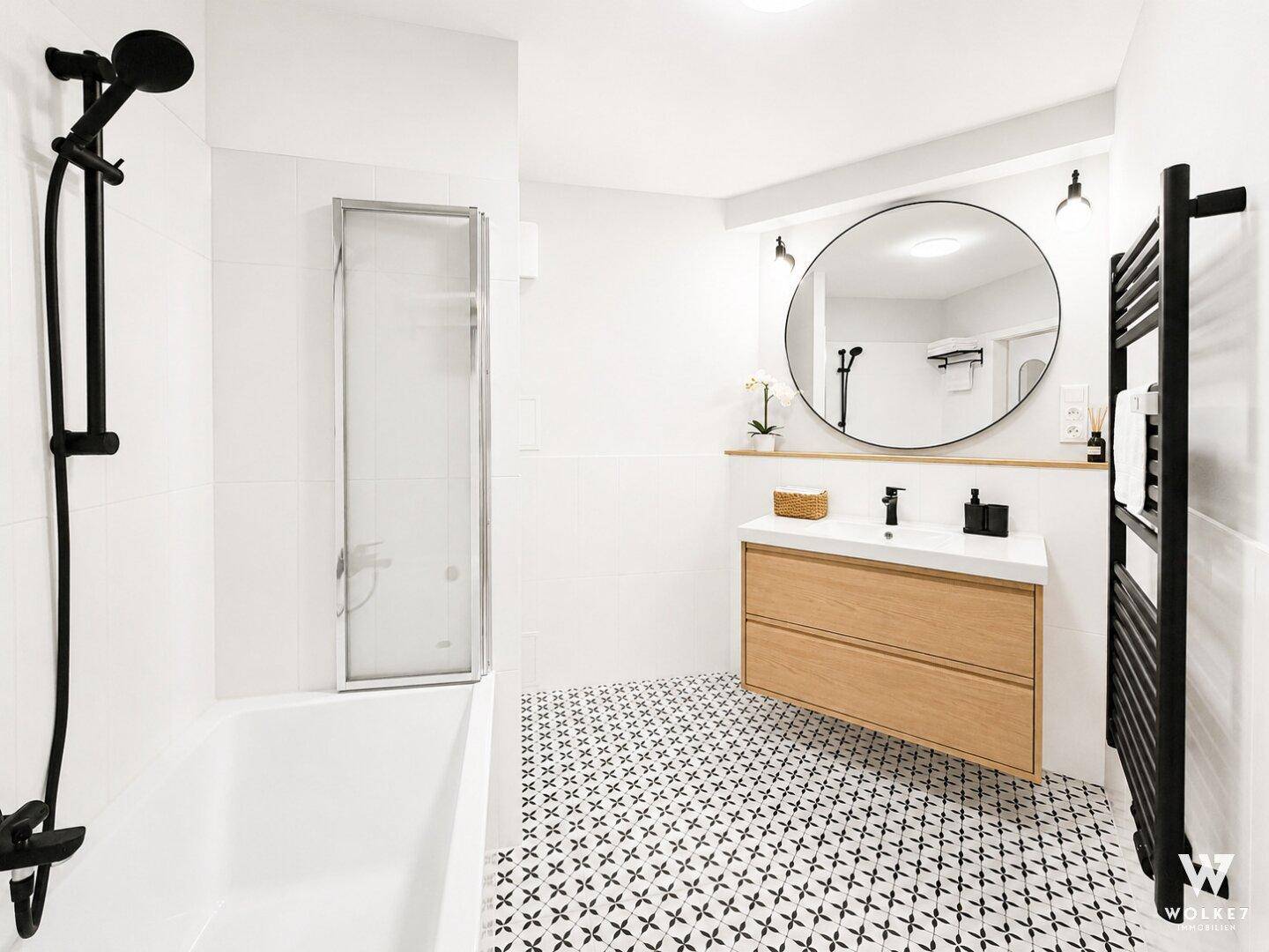Modernes Badezimmer mit Duschbereich, stilvollem Waschtisch und beheiztem Handtuchhalter.