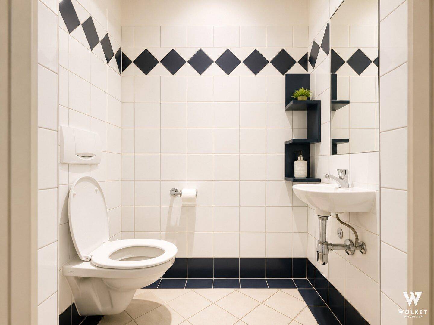 Kleines Gäste-WC mit schwarz-weiß gefliesten Wänden und Boden, ausgestattet mit Toilette und Waschbecken.