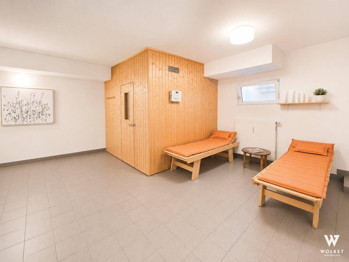 Entspannender Wellnessbereich mit einer Holzsauna und bequemen Liegen zum Ausruhen.