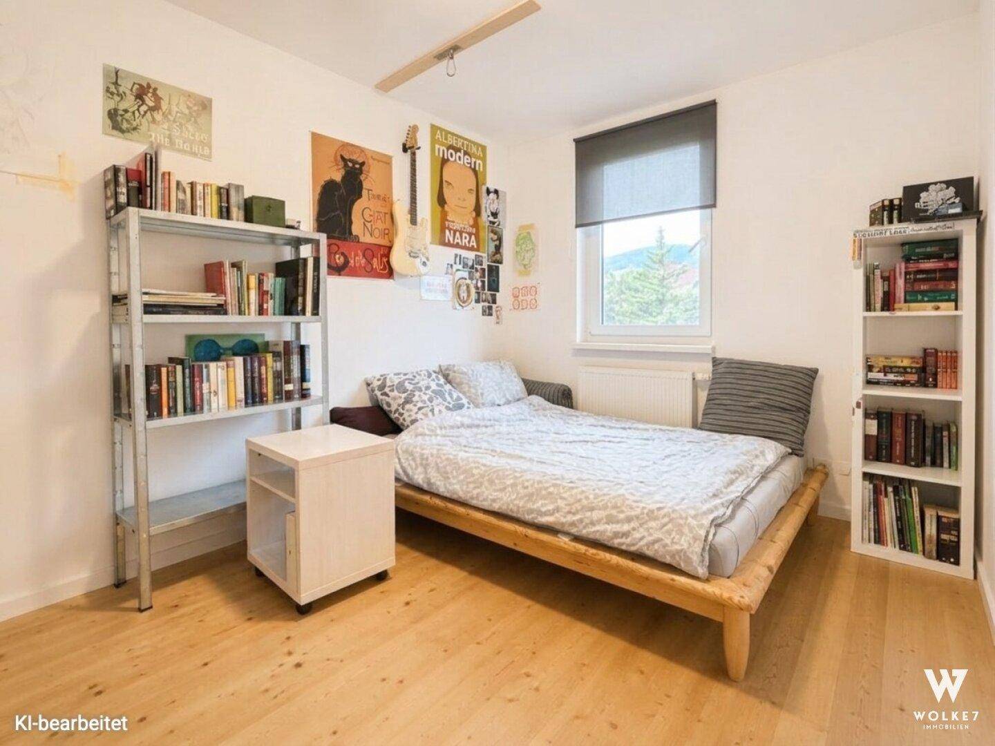 Schlafzimmer mit Holzbett, Bücherregalen und Fenster mit Blick auf die Umgebung.