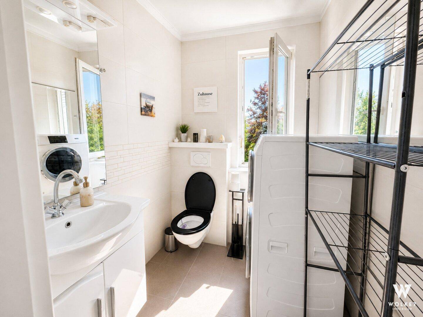 Modernes Gäste-WC mit Waschbecken, Toilette und Platz für Waschmaschine und Trockner.