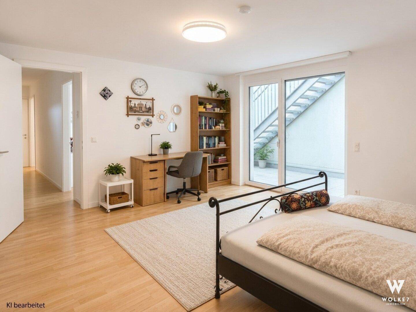 Schlafzimmer mit Holzboden, Arbeitsbereich und direktem Zugang zu einem Außenbereich.