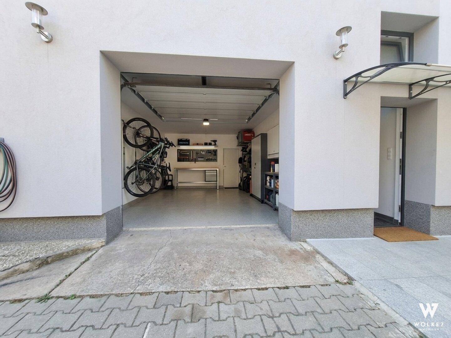 Geräumige Garage mit Stauraum, Werkbank und Fahrradaufhängung.