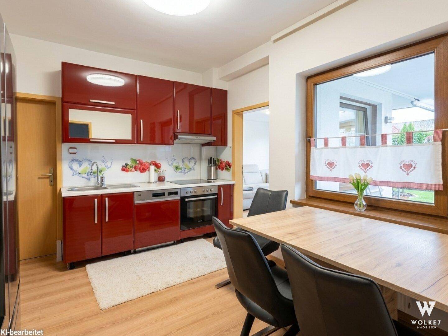 Moderne Küche mit roten Hochglanzfronten, Essbereich und Fenster mit Blick in den Garten.