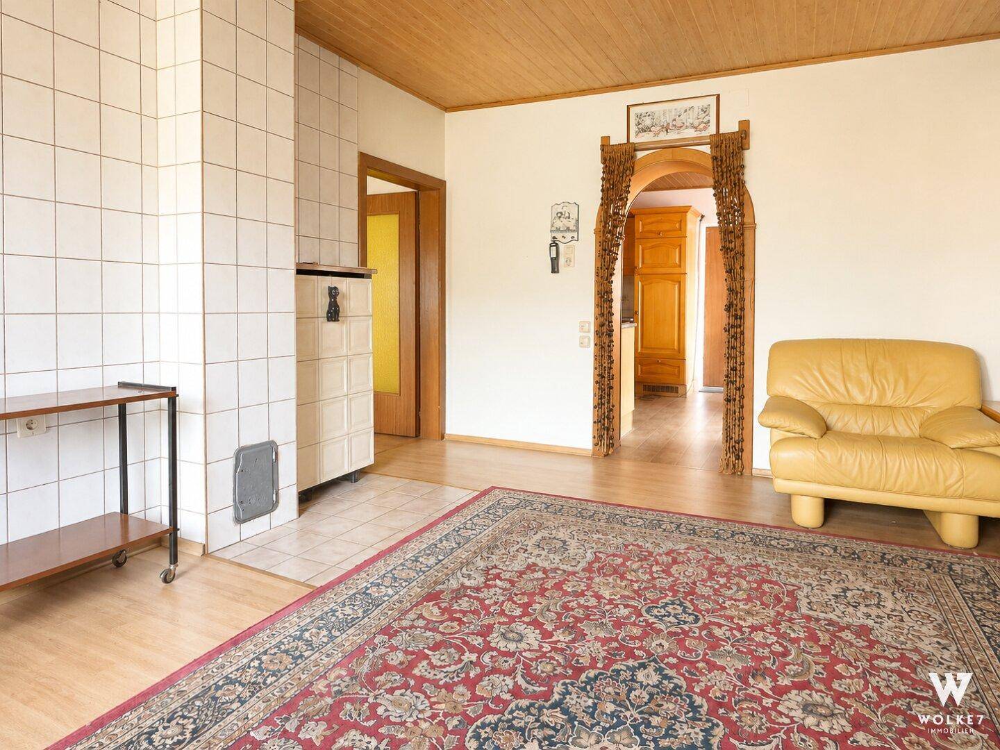 Wohnbereich mit Kachelofen, Holzboden und traditionellen Holzelementen.