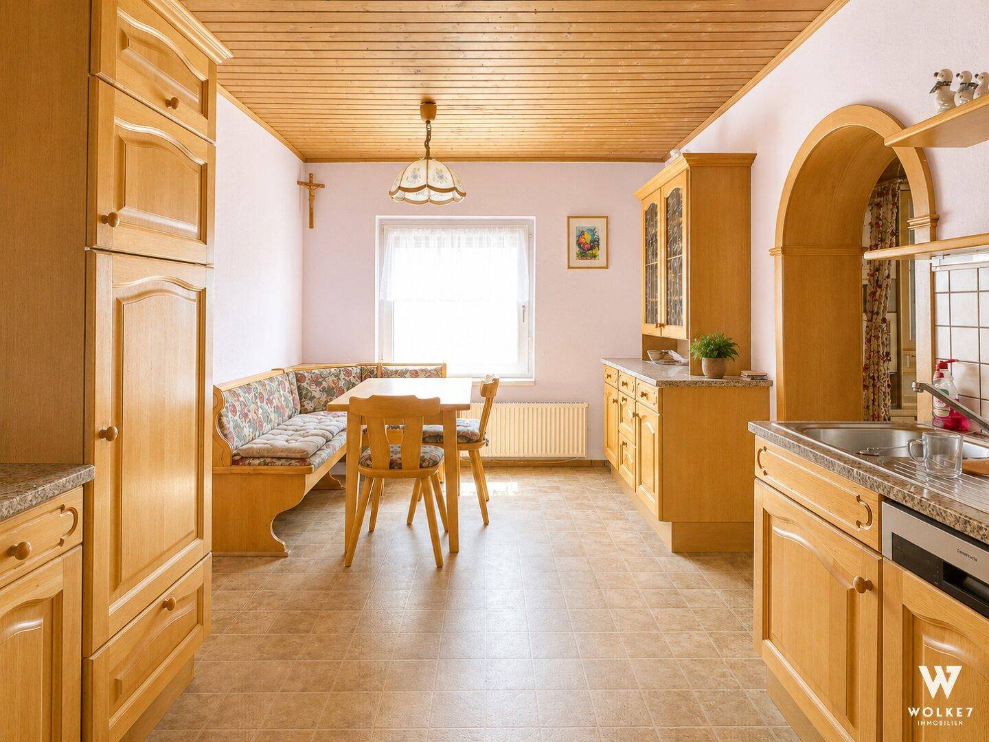Gemütliche Wohnküche im traditionellen Stil mit Holzmöbeln und Eckbank.