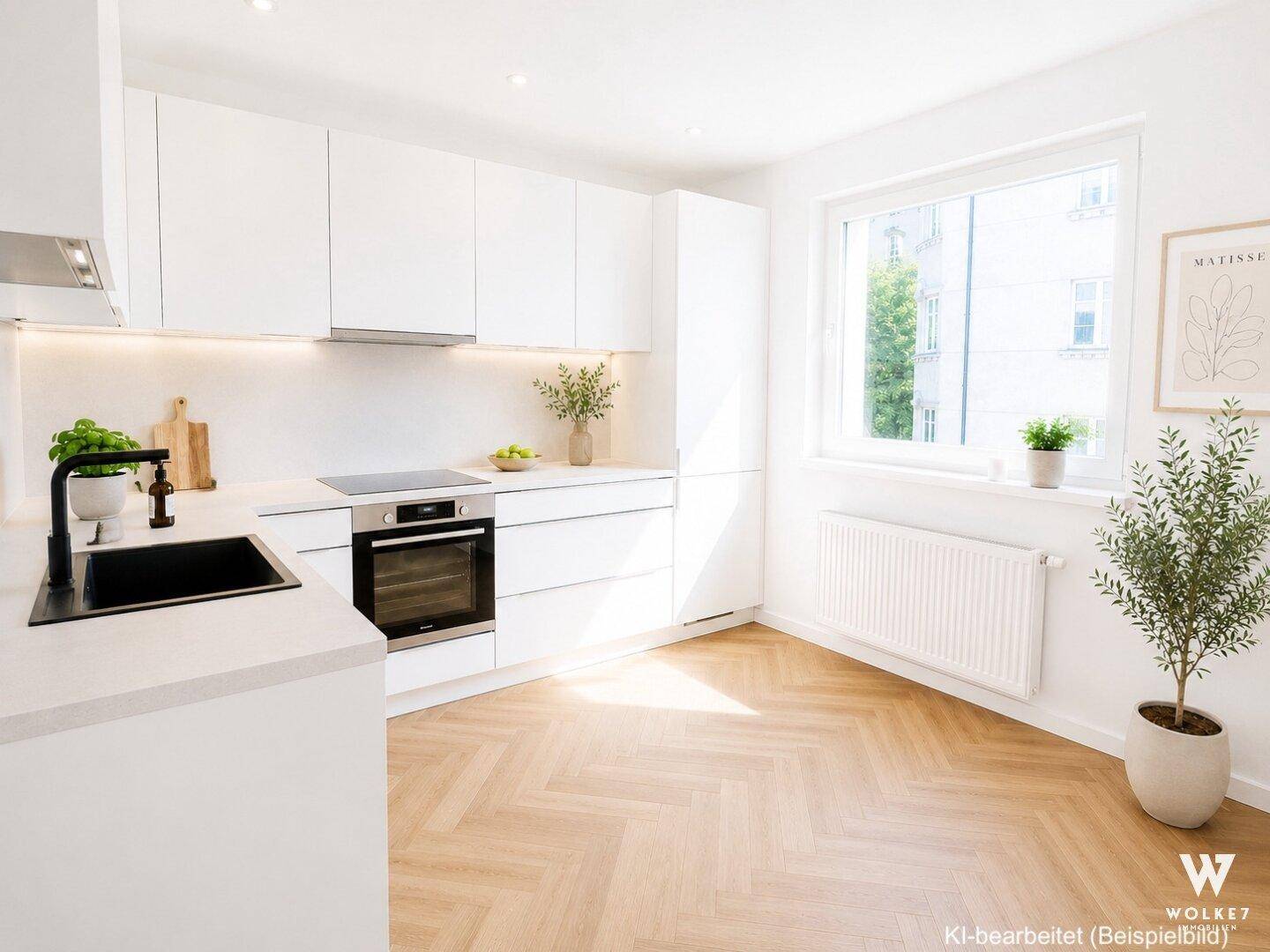 Moderne, helle Küche mit weißen Schränken, integrierten Geräten und Fensterblick ins Grüne.