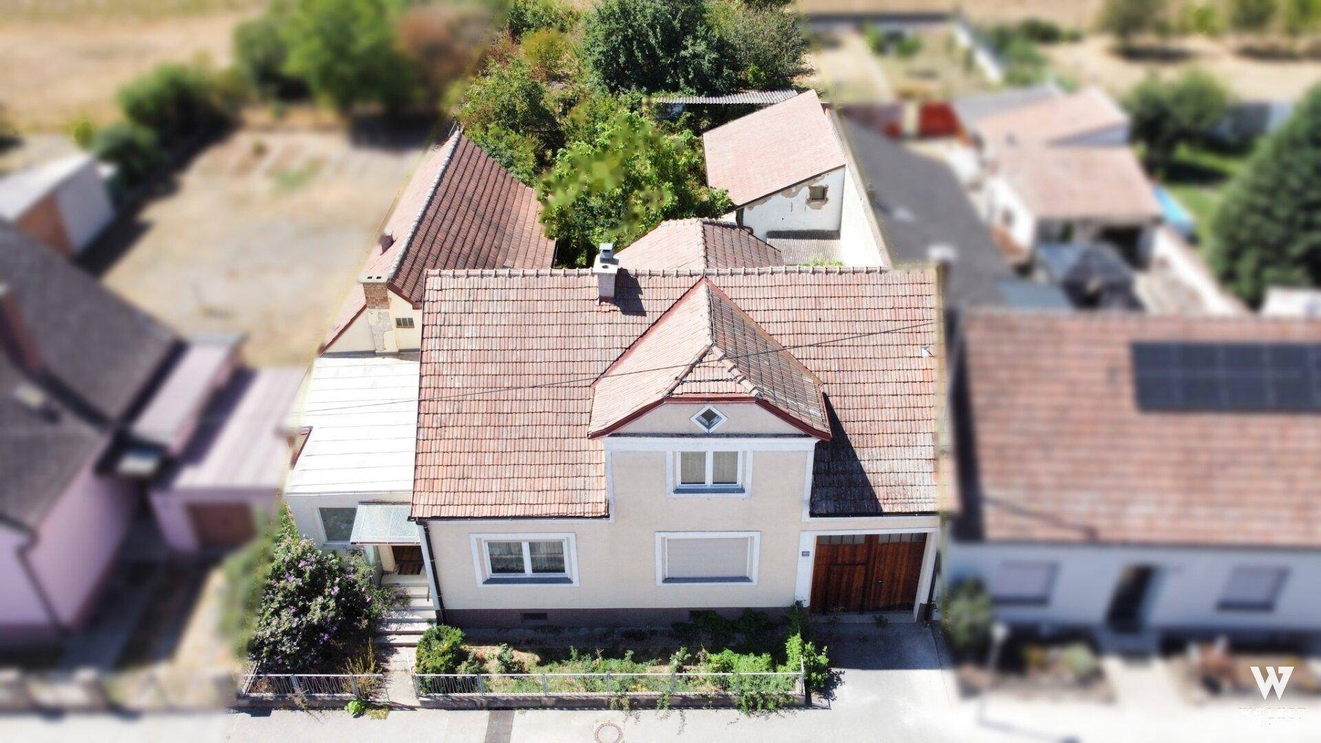 Detaillierte Luftaufnahme eines Einfamilienhauses mit Ziegeldach und gepflegter Fassade.