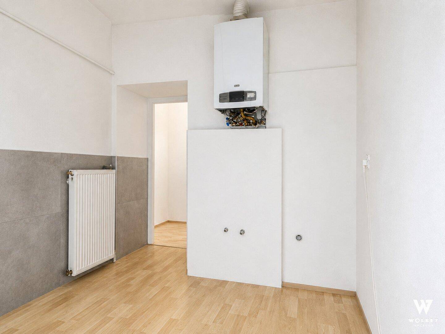 Raum mit Heizungsanlage, Heizkörper und Anschlüssen, ideal als Hauswirtschaftsraum oder Küche.