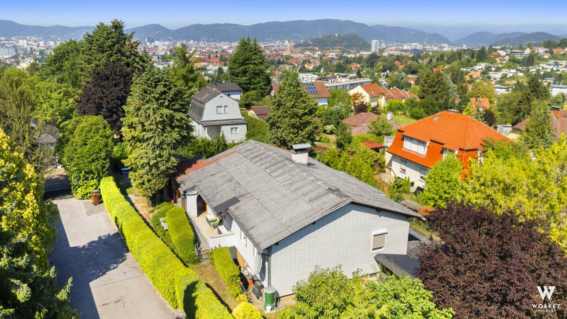 Luftaufnahme des Hauses mit Garten und weitem Blick über die Stadt.
