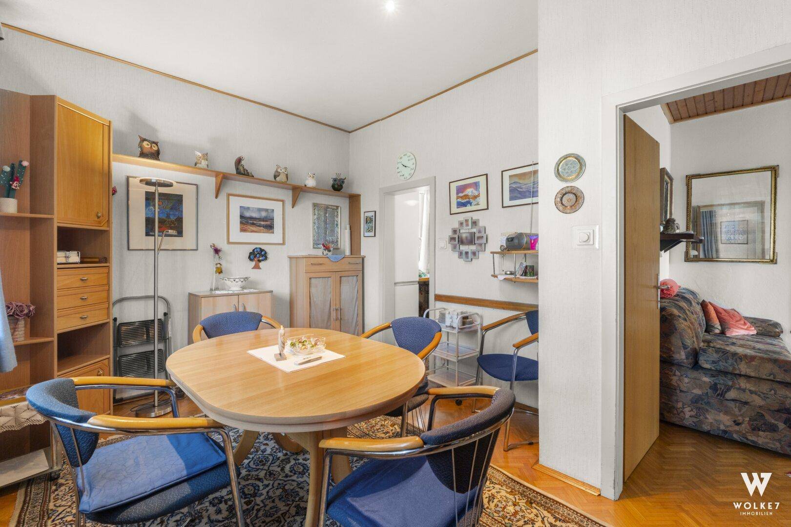 Essbereich mit Holztisch und Zugang zum angrenzenden Wohnzimmer.
