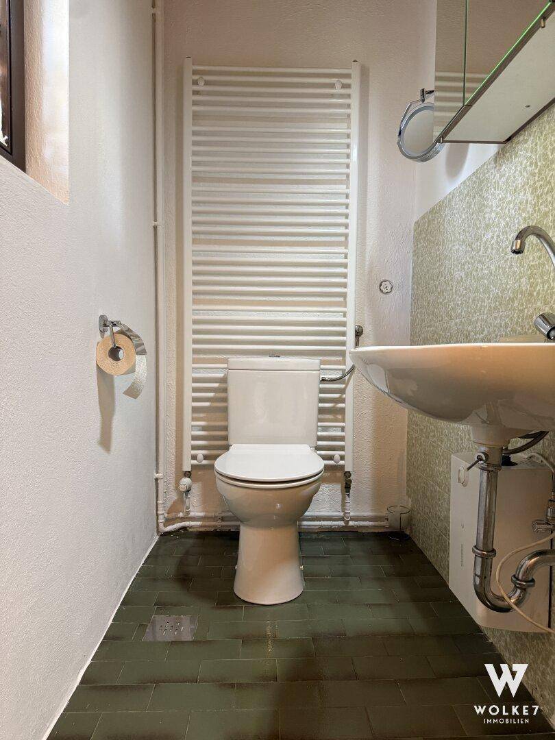 Kleines WC mit Waschbecken, Toilette und beheiztem Handtuchhalter.