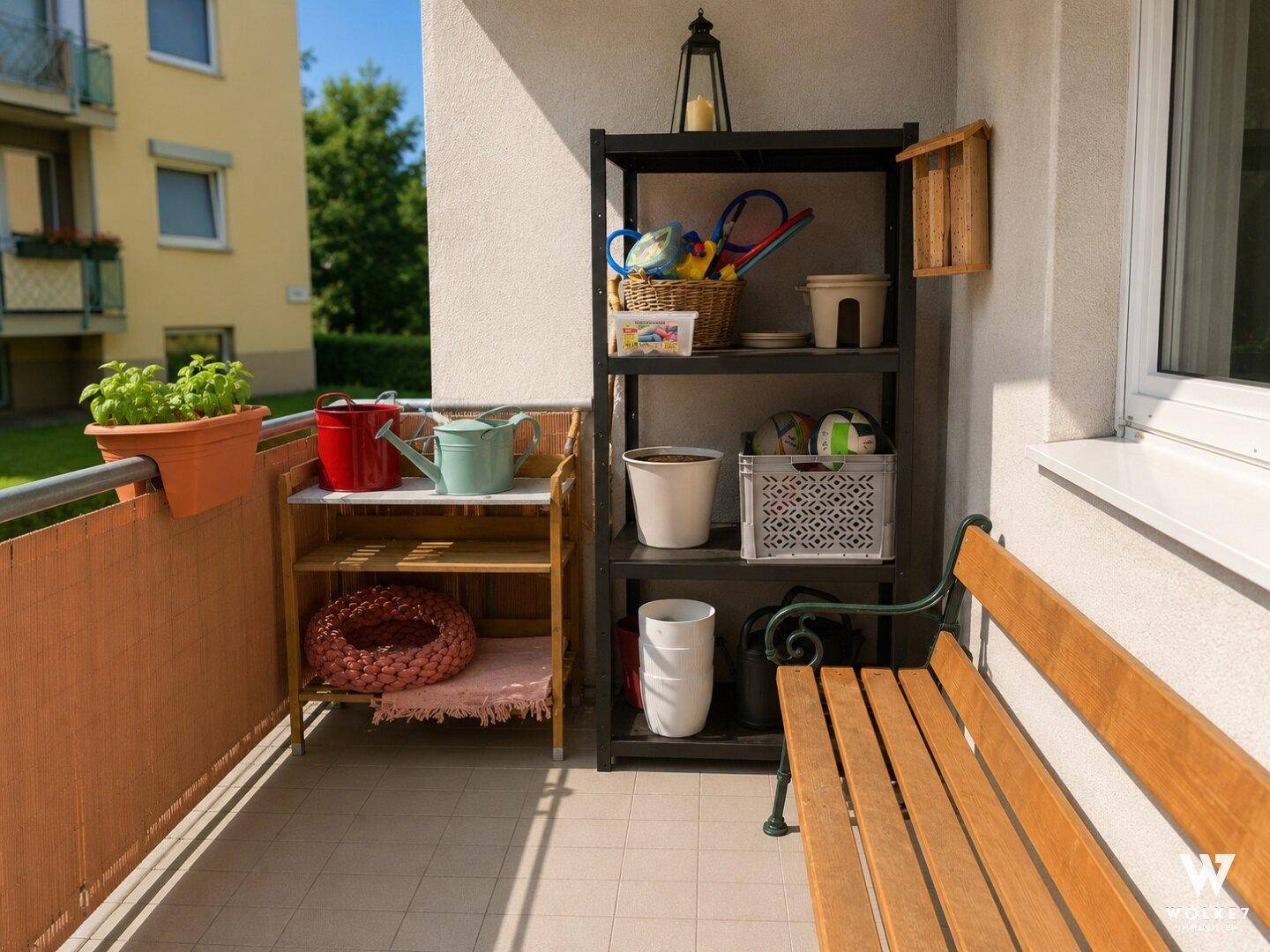 Sonniger Balkon mit Holzbank, Regalen und Pflanzen, ideal für Entspannung im Freien.
