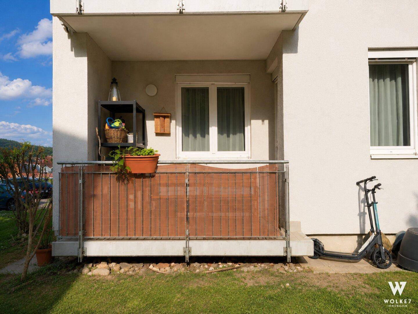 Erdgeschossbalkon mit Metallgeländer und Blick auf den angrenzenden Gartenbereich.