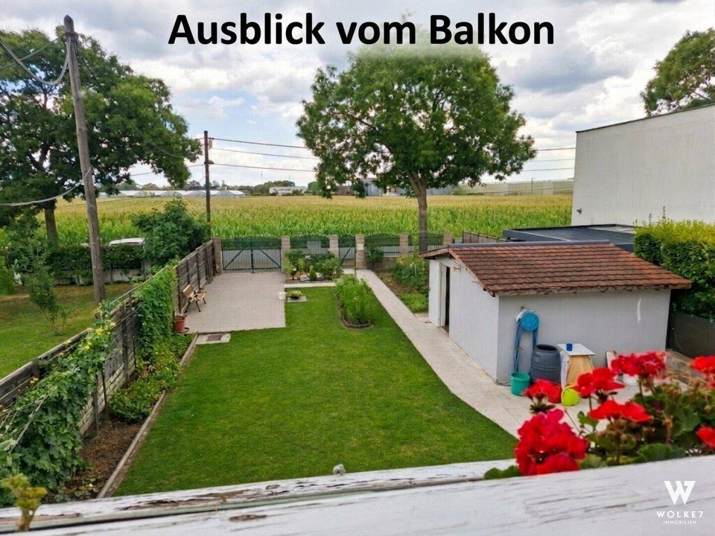 Weitläufiger Blick vom Balkon über den Garten und die umliegende Landschaft.