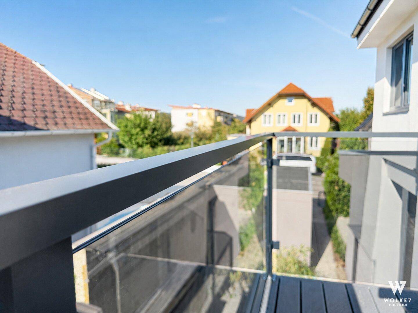 Detailansicht des modernen Balkongeländers aus Glas und Metall mit Weitblick.