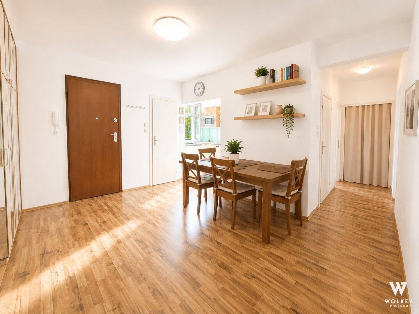 Heller Essbereich mit Holztisch und Stühlen, Laminatboden und Zugang zum Flur.