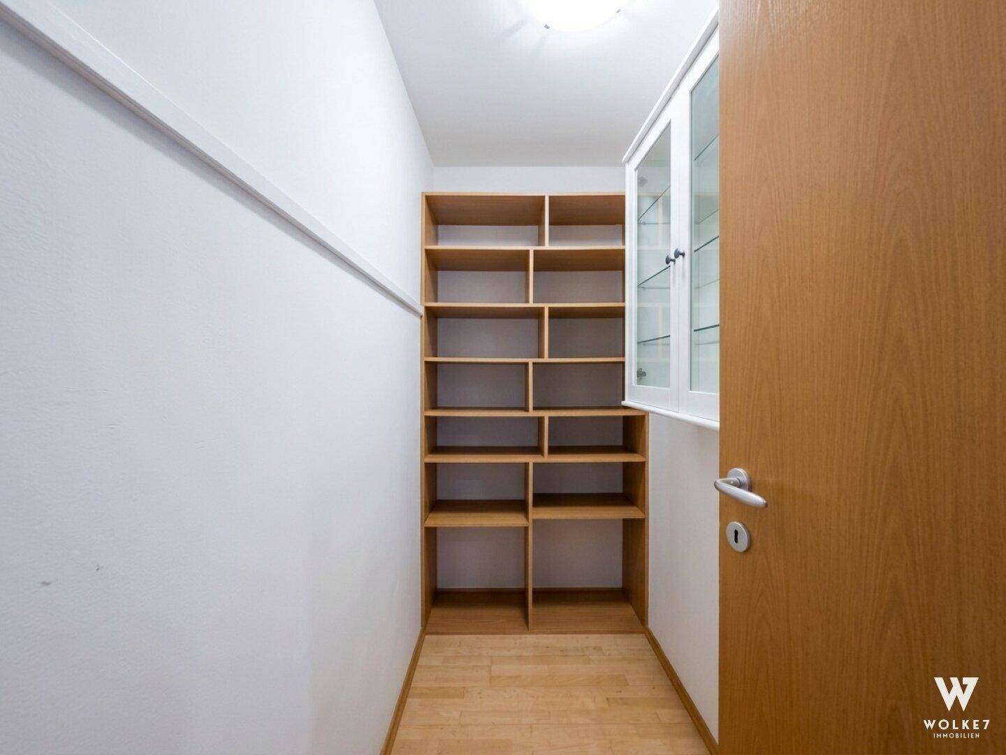 Praktischer Abstellraum mit Regalsystem und Holzboden, bietet viel Stauraum.