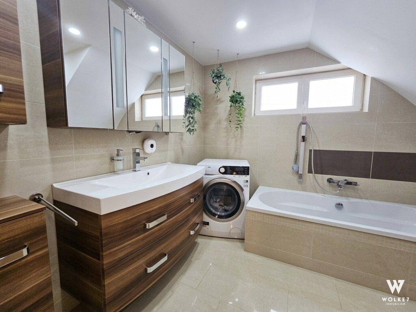 Modernes Badezimmer mit Badewanne, großem Waschbecken und Holzunterschrank.
