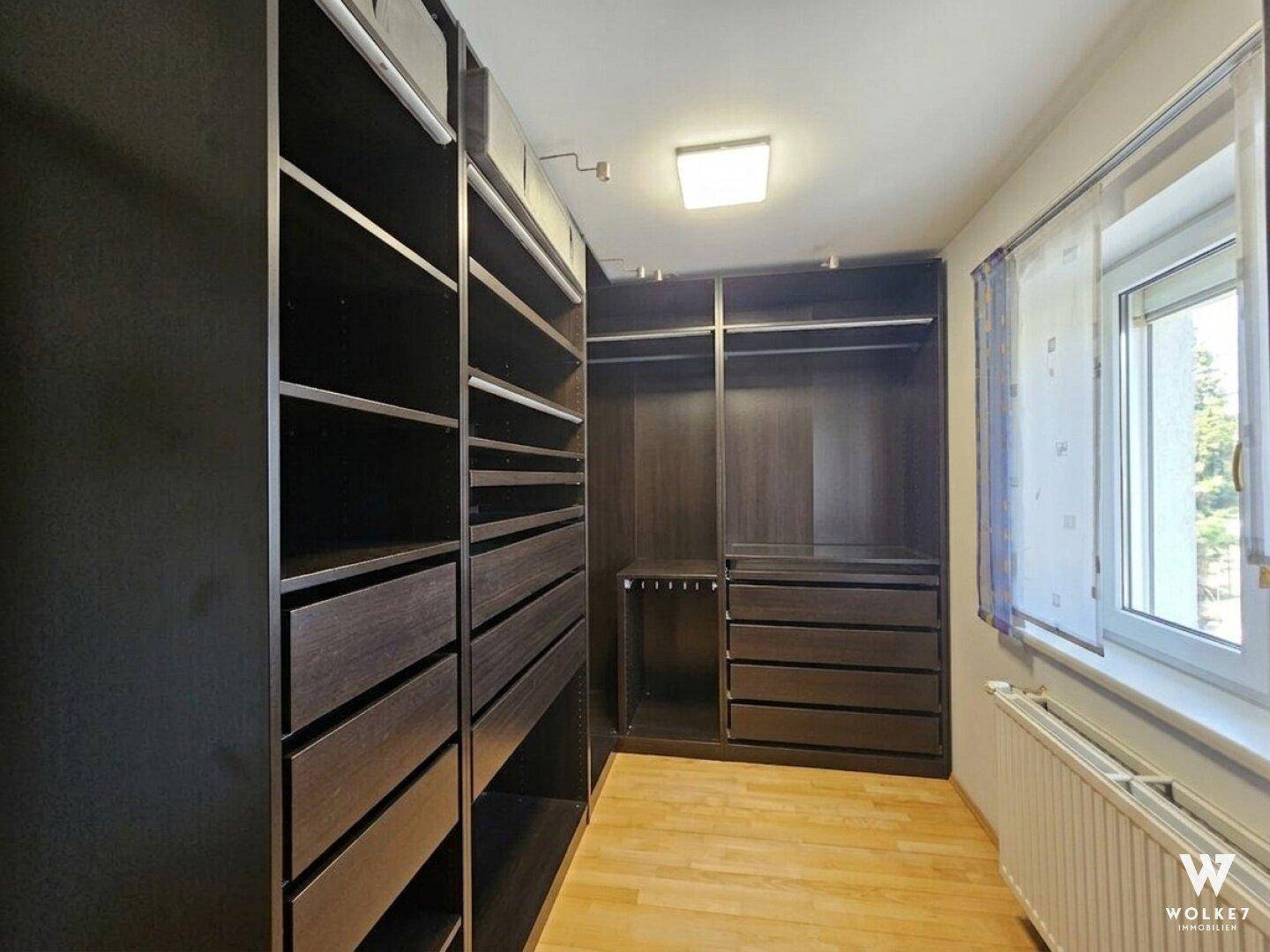 Begehbarer Kleiderschrank mit umfangreichen Regalen und Schubladen, bietet viel Stauraum.