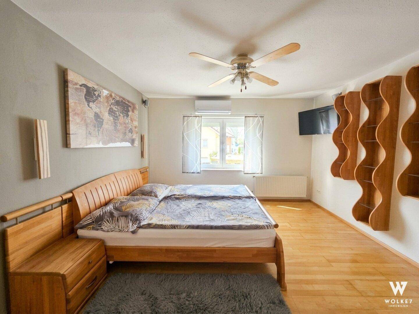 Geräumiges Schlafzimmer mit Doppelbett, Deckenventilator und Holzboden.