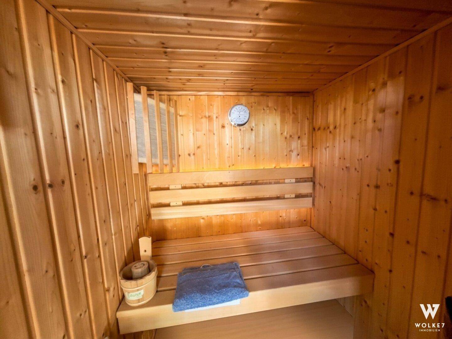 Traditionelle Holzsauna mit Holzbänken und einem klassischen Saunaofen für entspannende Momente.