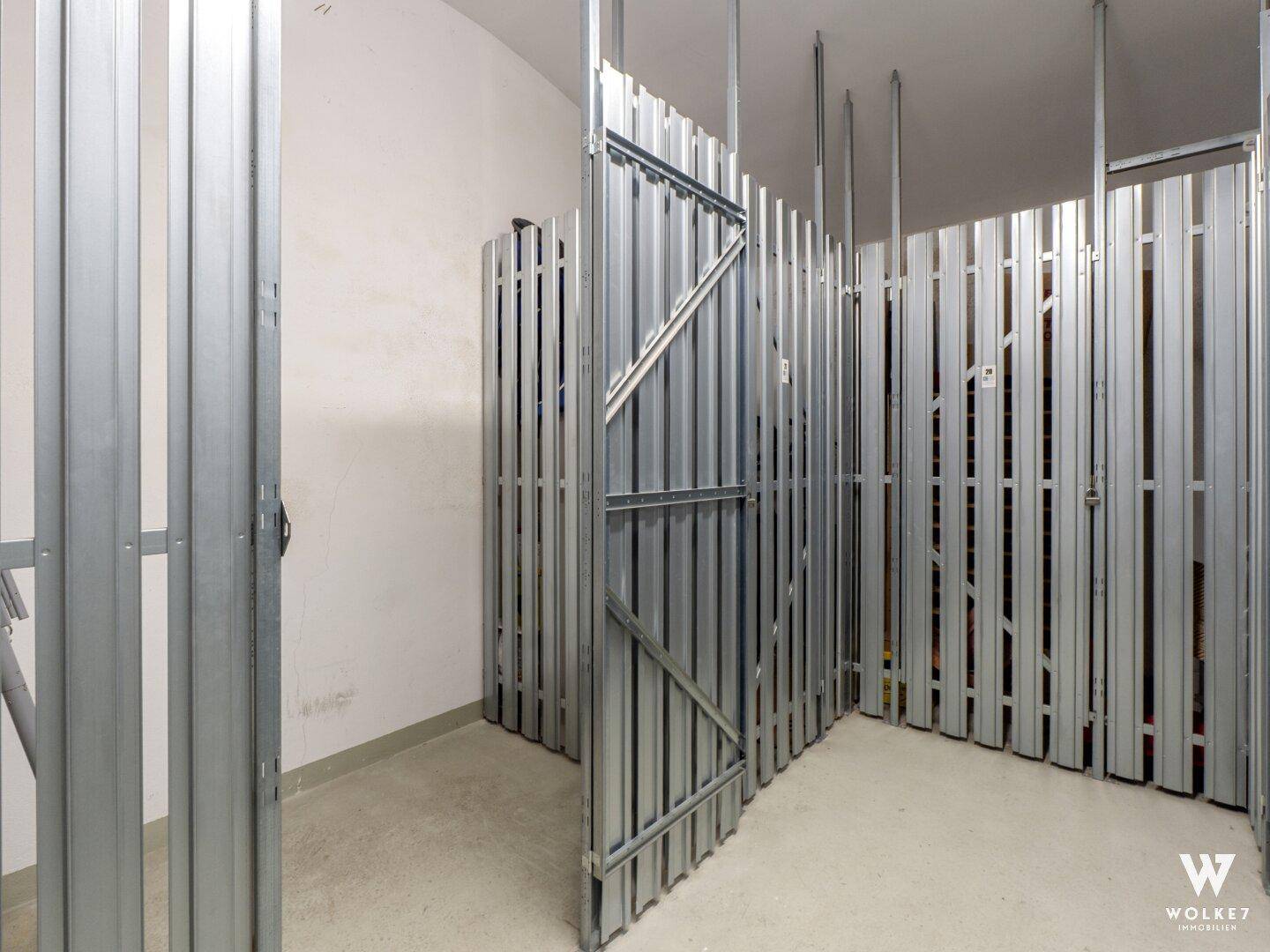 Praktische Abstellräume mit Metallabtrennungen im Kellerbereich für zusätzlichen Stauraum.